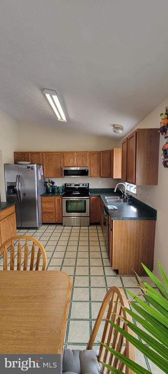 kitchen with sink, light tile patterned floors, and stainless steel appliances