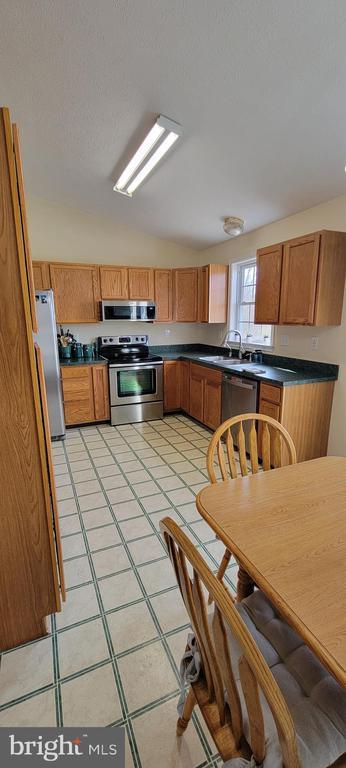 kitchen with appliances with stainless steel finishes, sink, and a textured ceiling