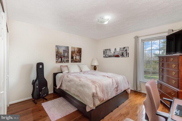 bedroom featuring a textured ceiling and light wood-type flooring