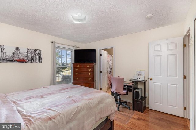 bedroom featuring light hardwood / wood-style flooring and a textured ceiling