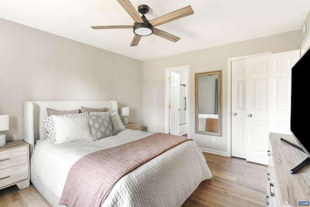 bedroom with light wood-style flooring, baseboards, ensuite bathroom, and ceiling fan