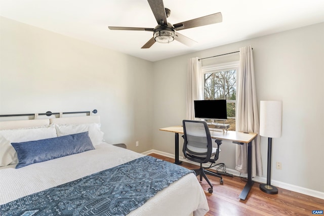 bedroom featuring a ceiling fan, baseboards, and wood finished floors