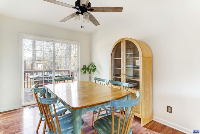 dining area featuring visible vents, baseboards, ceiling fan, and wood finished floors