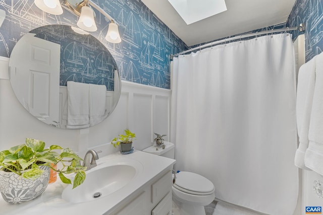 bathroom with walk in shower, vanity, toilet, and a skylight