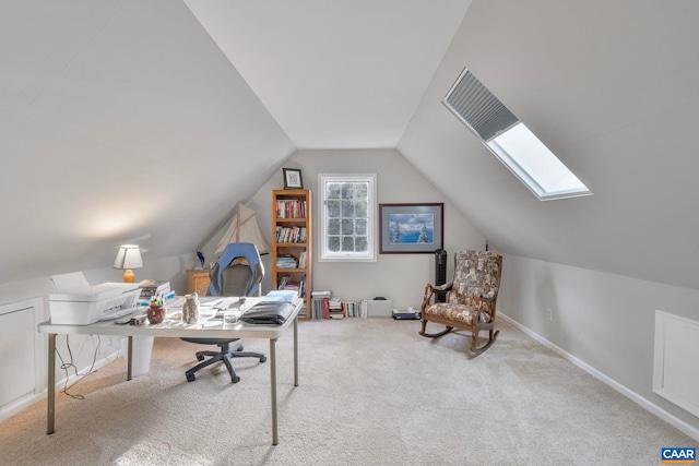 carpeted office featuring vaulted ceiling with skylight