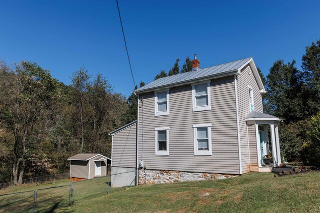 view of side of property with a lawn and a shed