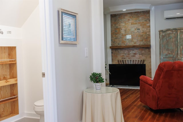 living area with dark hardwood / wood-style flooring, a brick fireplace, and a wall mounted AC