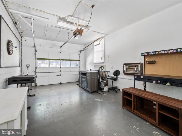 garage with a garage door opener and an AC wall unit