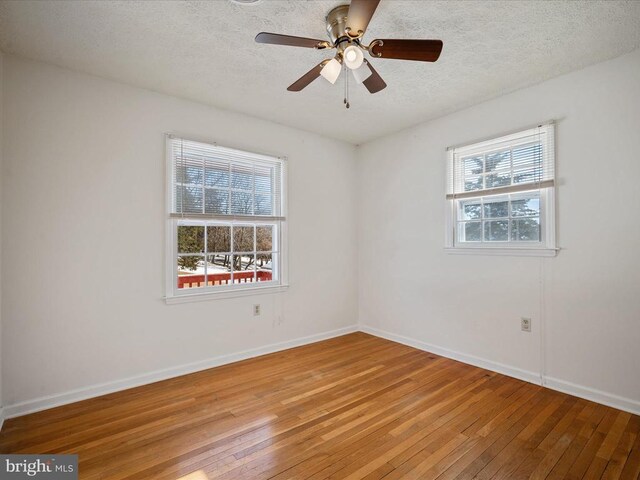 spare room featuring a healthy amount of sunlight, a textured ceiling, and light wood-type flooring