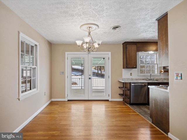 kitchen featuring dark brown cabinets, light hardwood / wood-style flooring, a chandelier, and dishwasher