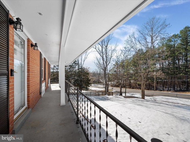 view of snow covered back of property