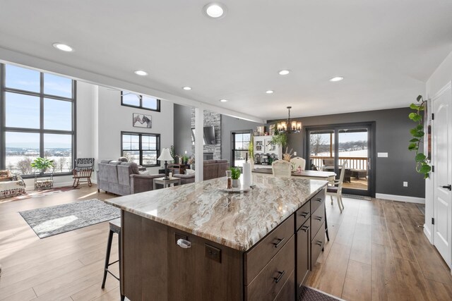 kitchen with hanging light fixtures, a center island, an inviting chandelier, and light wood-type flooring