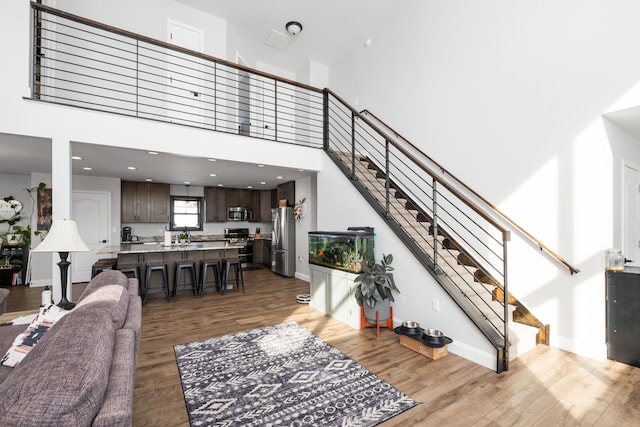 living room with wood-type flooring and a high ceiling