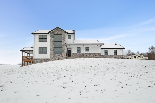 view of snow covered back of property