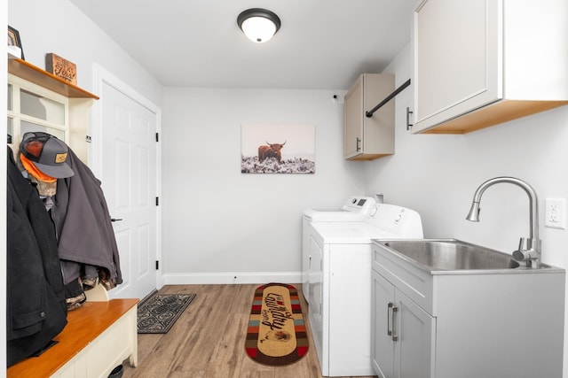 washroom featuring light hardwood / wood-style floors, cabinets, washer and clothes dryer, and sink