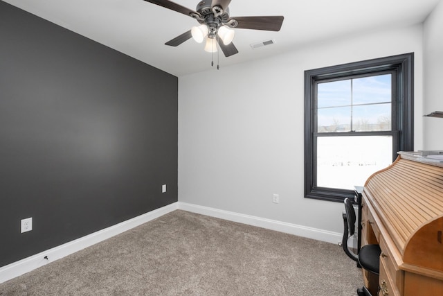 unfurnished office featuring ceiling fan, plenty of natural light, and carpet