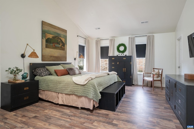 bedroom featuring visible vents, vaulted ceiling, and dark wood-style flooring