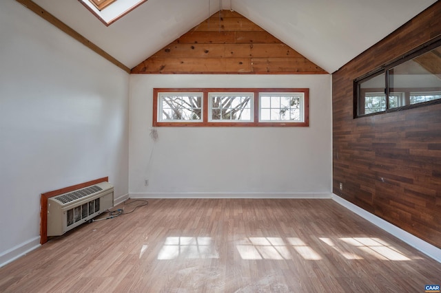 interior space with a wealth of natural light, heating unit, and wood finished floors