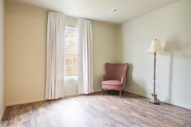 unfurnished room featuring wood finished floors, visible vents, and baseboards