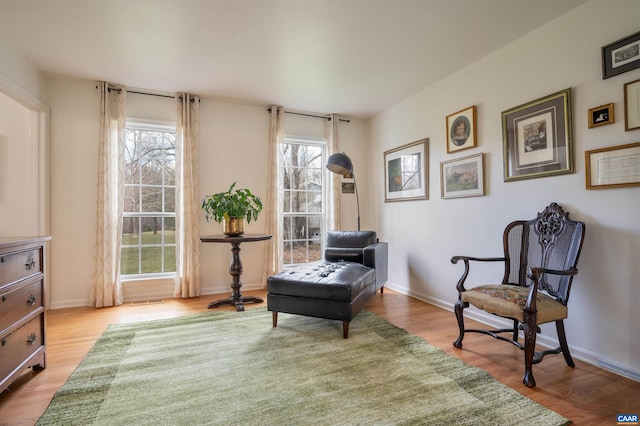 sitting room with baseboards and wood finished floors