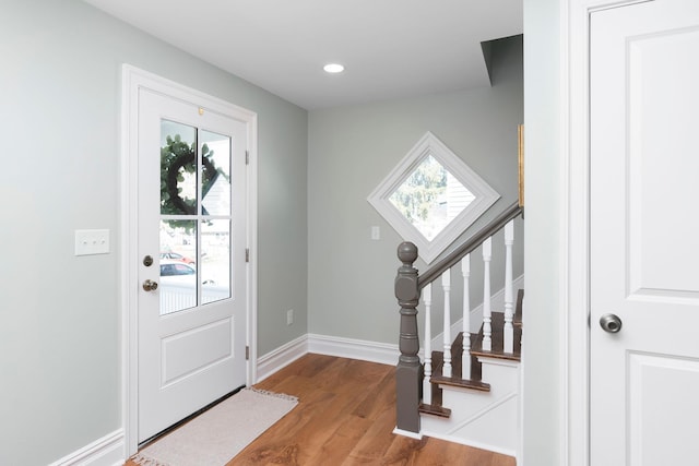 entryway with plenty of natural light, stairway, baseboards, and wood finished floors