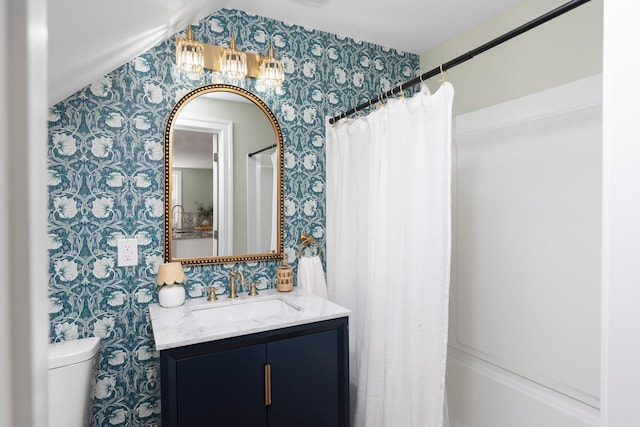 full bath with toilet, wallpapered walls, vanity, and shower / tub combo