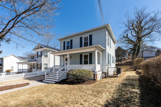 traditional style home featuring covered porch, a front lawn, and fence