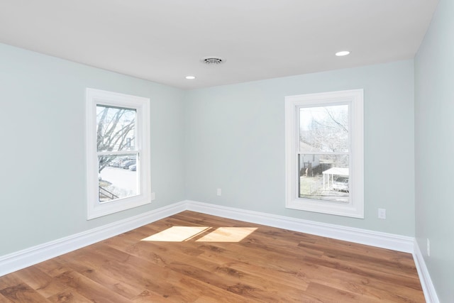 unfurnished room featuring visible vents, recessed lighting, baseboards, and wood finished floors