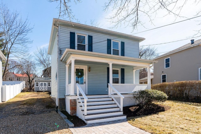 traditional style home featuring fence and covered porch