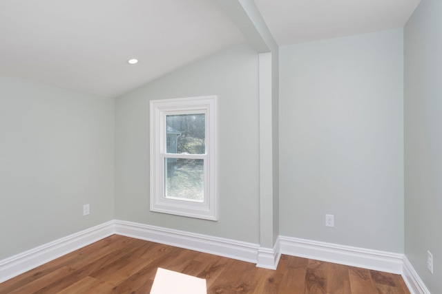 additional living space featuring vaulted ceiling, wood finished floors, and baseboards