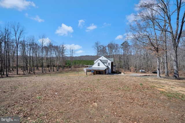 view of yard with a rural view and a forest view