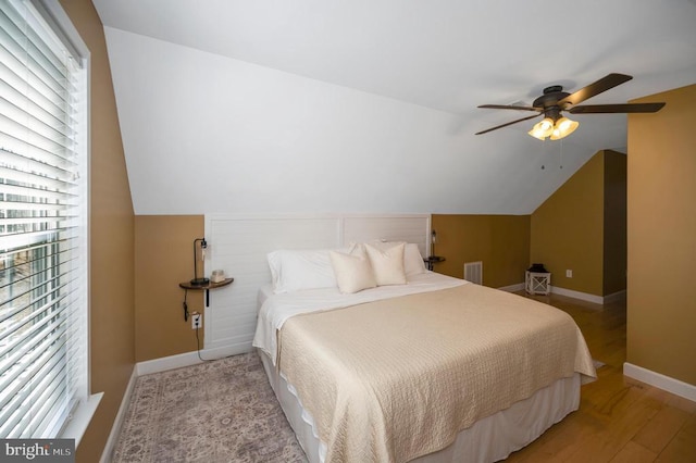 bedroom featuring a ceiling fan, baseboards, visible vents, lofted ceiling, and light wood-style flooring