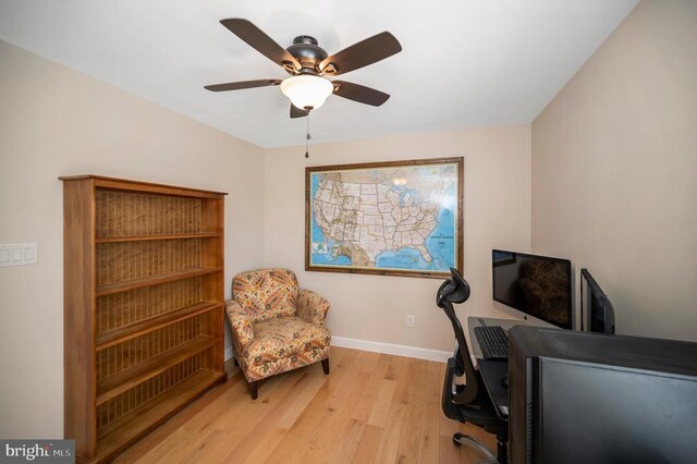 office space with light wood-style flooring, baseboards, and ceiling fan