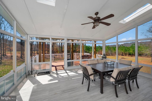 sunroom / solarium with vaulted ceiling with skylight and a healthy amount of sunlight