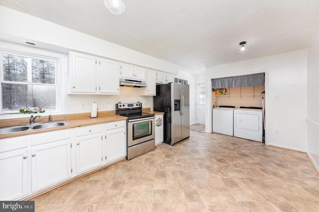 kitchen with stainless steel appliances, white cabinetry, a sink, separate washer and dryer, and under cabinet range hood