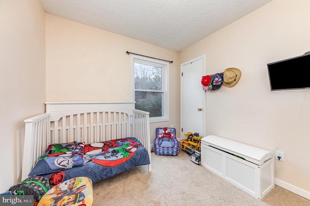 carpeted bedroom featuring a textured ceiling and baseboards