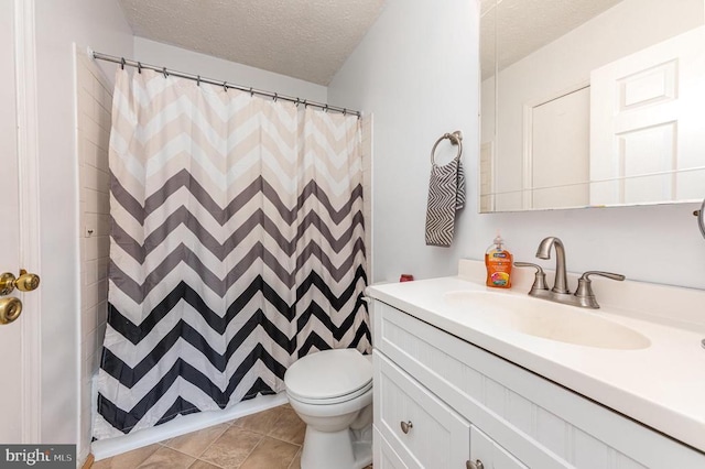 bathroom featuring toilet, curtained shower, tile patterned flooring, a textured ceiling, and vanity