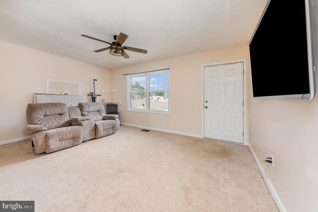 sitting room with light carpet, baseboards, visible vents, a ceiling fan, and a textured ceiling