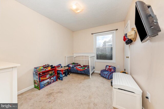 bedroom with baseboards, a textured ceiling, and light colored carpet