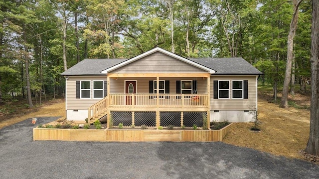 view of front of home with crawl space, stairway, a porch, and roof with shingles