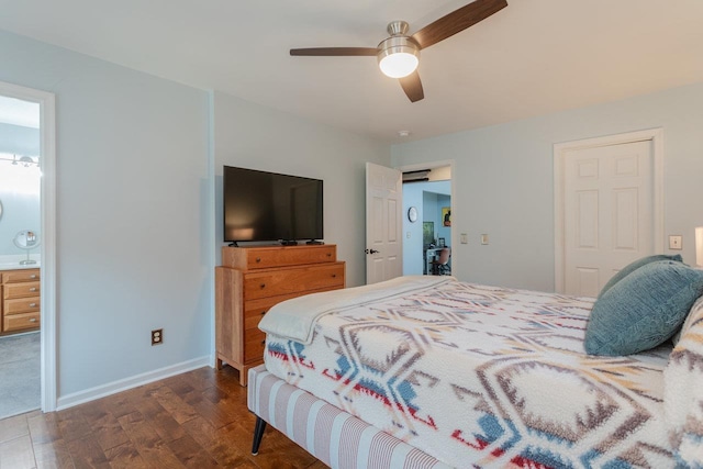 bedroom with ceiling fan, connected bathroom, baseboards, and wood finished floors