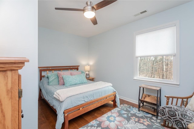 bedroom featuring visible vents, baseboards, wood finished floors, and a ceiling fan