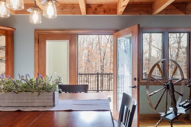 dining room with beam ceiling and wood finished floors