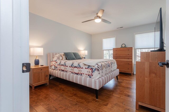 bedroom featuring hardwood / wood-style flooring, a ceiling fan, and visible vents