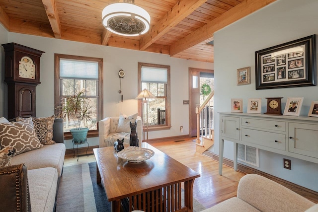 living area featuring visible vents, beamed ceiling, light wood-style flooring, stairway, and wood ceiling