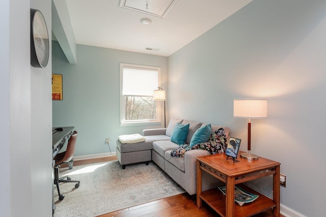 home office featuring visible vents, baseboards, attic access, and wood finished floors