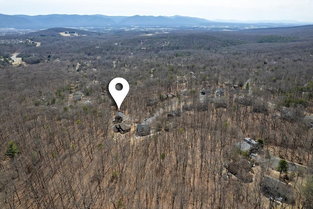 birds eye view of property featuring a wooded view and a mountain view