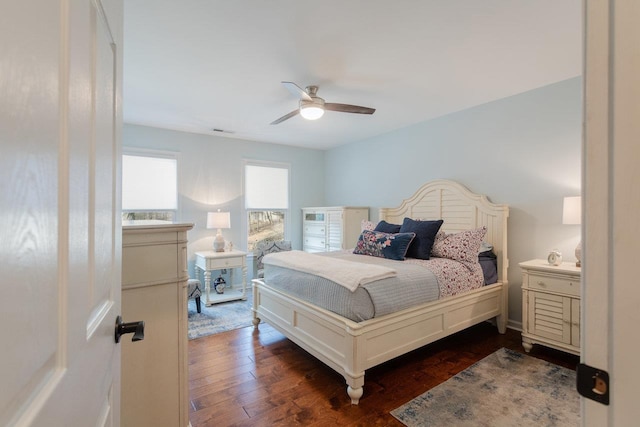 bedroom with dark wood-style floors, visible vents, and ceiling fan