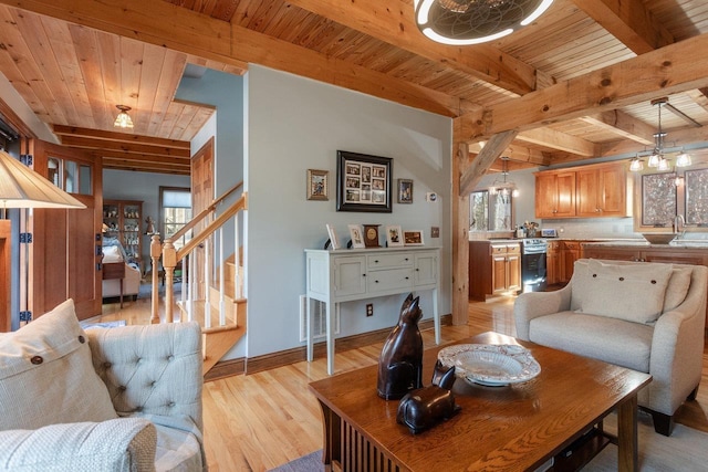 living area with stairway, baseboards, light wood finished floors, beam ceiling, and wood ceiling