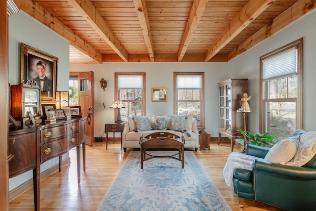 living room featuring light wood-type flooring, beamed ceiling, baseboards, and wooden ceiling